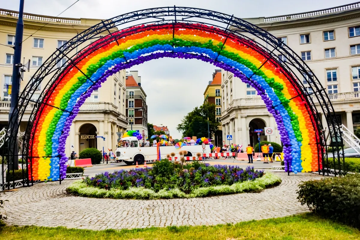 Rainbow balloon arch framing a busy city street